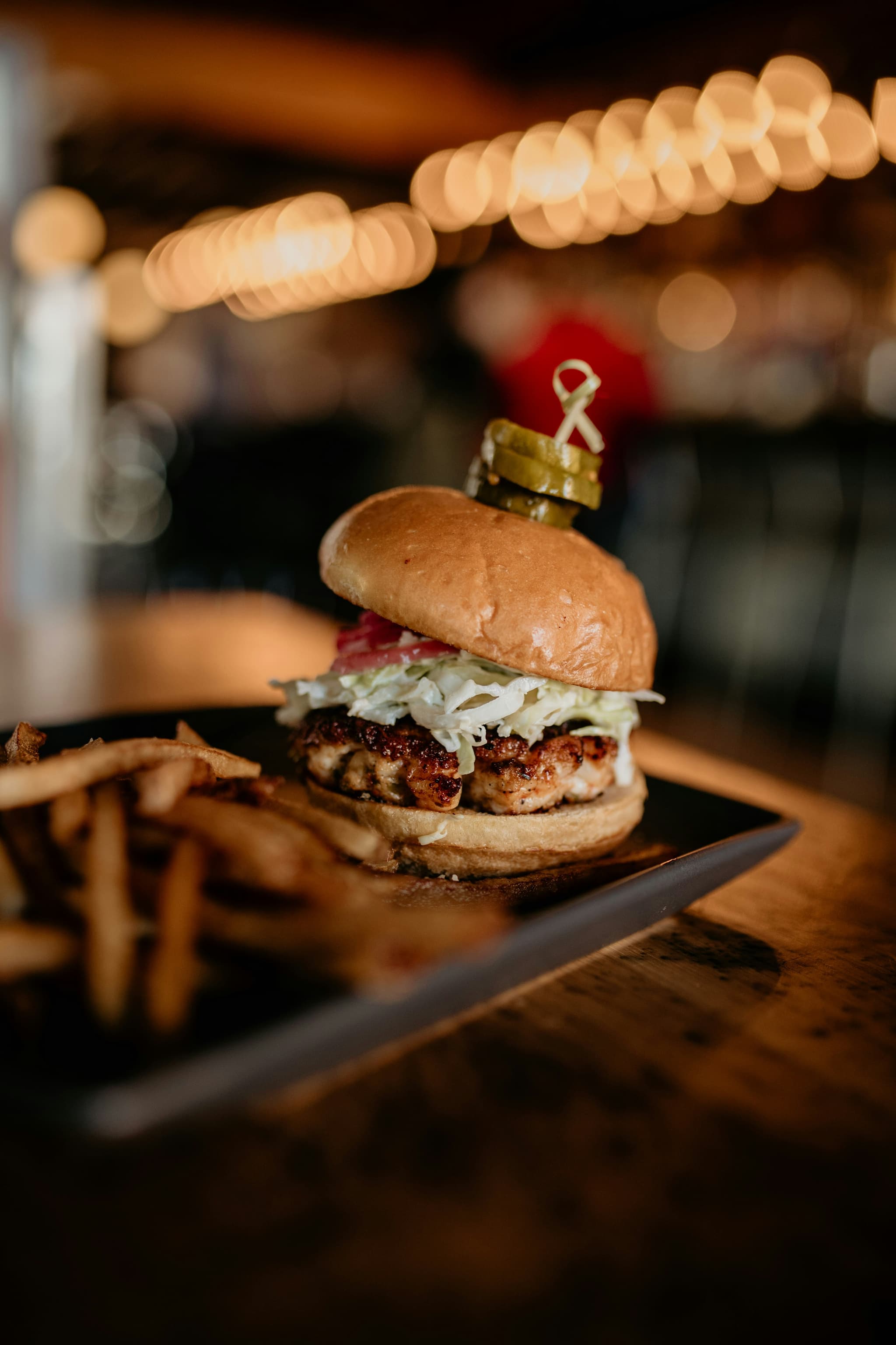 Eight shirts arranged on table in black, olive, grey, blue, white, red, mustard, and green.